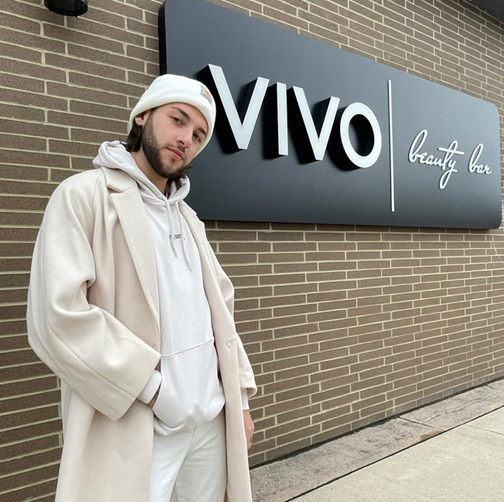guys in front of Vivo sign with white hat, white coat, white hoodie and white pants